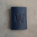 Blueberry leather passport cover with a large floral initial W pressed into the front
