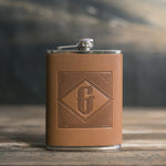 Caramel leather hip flask with an initial pressed into the diamond frame