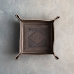 Country Gray leather valet tray with snapped corners and the initials KRJ pressed into the diamond frame, seen from above