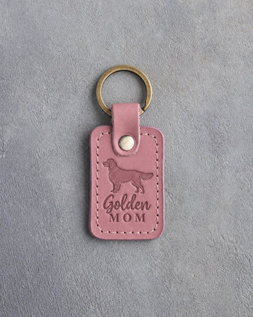 Pink Parisian Blossom leather keychain with a debossed golden retriever and the words Golden MOM on gray concrete