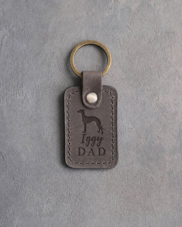 Country gray leather keychain debossed with an Italian Greyhound silhouette and the words Iggy DAD, on gray concrete