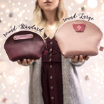 Round makeup bags in standard and large sizes held side by side in sangria and blush leather