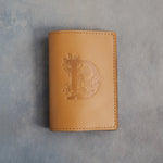 Indian Summer leather passport cover with a large floral initial D pressed into the front