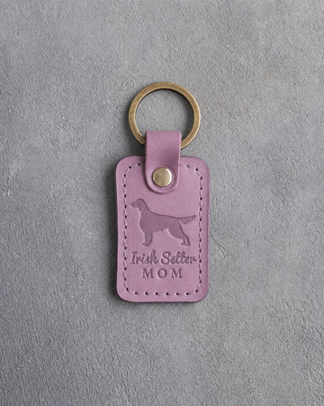Lilac leather keychain debossed with an Irish Setter silhouette and the words Irish Setter MOM, on gray concrete