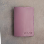 Lilac leather passport cover with a name in small script pressed into the bottom corner