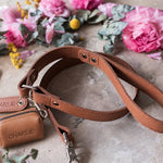 Caramel leather dog leash with a matching zip poop bag holder, both with the name Charlie