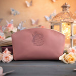Parisian blossom leather makeup bag with a floral monogram deboss, roses and a lit lantern in the background