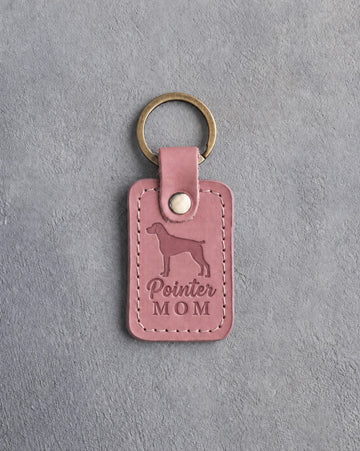 Parisian Blossom pink leather keychain debossed with a German Shorthaired Pointer silhouette and the words Pointer MOM, on gray concrete