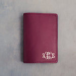 Sangria leather passport cover with a vine monogram pressed into the bottom corner