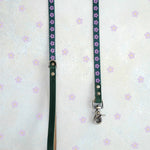 Two thin webbing leashes in green and lilac hanging side by side