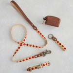 Thin webbing leash in cream and red with a matching collar, keychain and leather bag holder