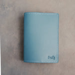 Turquoise leather passport cover with the name Emily in cursive pressed into the bottom corner