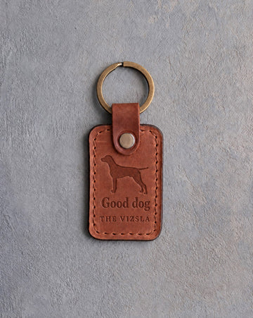 Arizona tan leather keychain debossed with a vizsla above Good dog and THE VIZSLA, on gray concrete