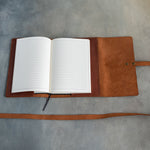 Open leather journal with lined pages and bookmark