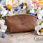 Caramel leather makeup pouch debossed with a floral letter T, white anemones behind