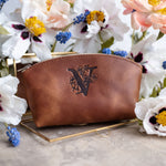 Caramel arizona leather makeup bag debossed with a floral letter V, spring flowers around