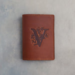 Arizona leather passport cover with a large floral initial V pressed into the front