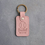 Blush pink leather keychain debossed with a baseball and the words Baseball MOM, on gray plaster