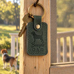 Forest green Beagle Dad leather keychain held in a warm everyday setting