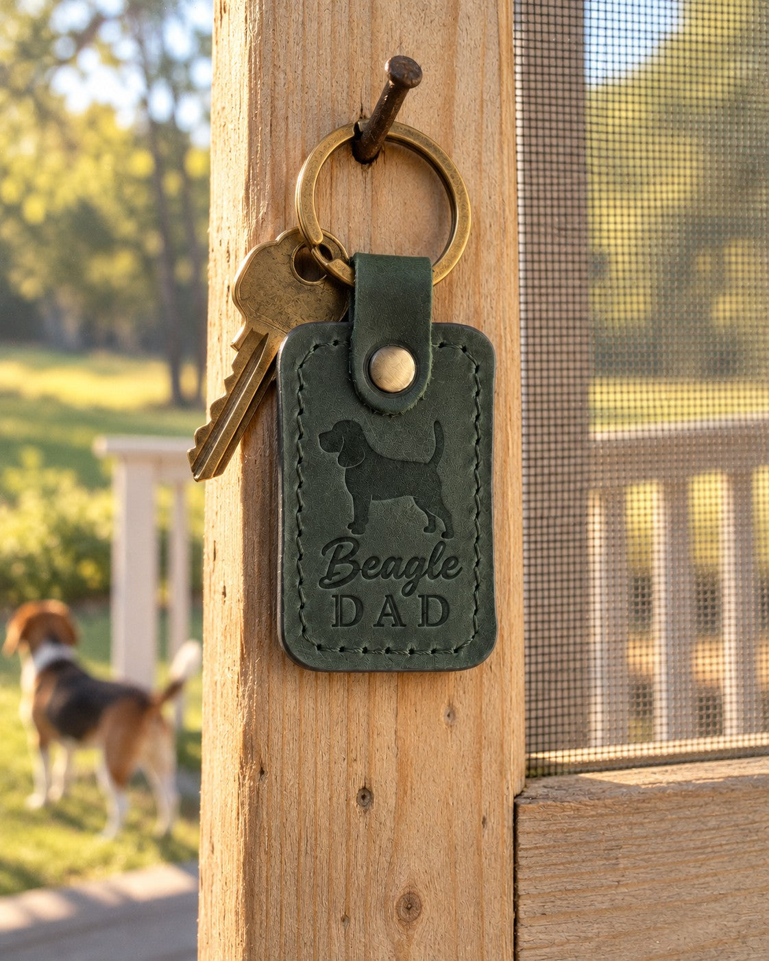 Forest green Beagle Dad leather keychain held in a warm everyday setting