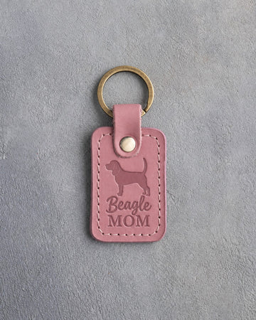 Parisian Blossom pink leather keychain debossed with a Beagle silhouette and the words Beagle MOM, on gray concrete