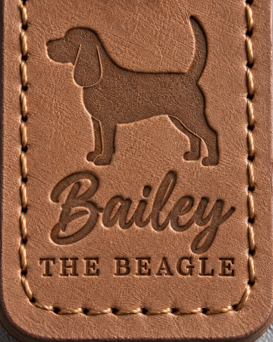 Close-up of Bailey in brush script and THE BEAGLE pressed into caramel full-grain leather beneath a Beagle silhouette