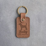 Caramel leather keychain debossed with a Beagle silhouette, the name Bailey and THE BEAGLE, on gray concrete