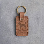 Caramel leather keychain debossed with a Beagle silhouette above Best friend and THE BEAGLE, on gray concrete