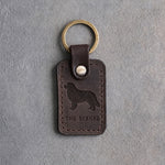 Dark espresso leather keychain debossed with a Bernese mountain dog above THE BERNER, on gray concrete