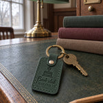 Green Book club FINISHED IT keychain on a closed novel bristling with sticky notes at a book club table