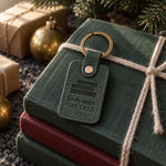 Green Books under THE TREE keychain on a yarn-tied stack of books at the foot of a fir tree