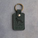Forest green leather keychain with a debossed border collie and the words Collie DAD on gray concrete