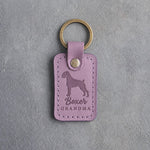 Lilac leather keychain debossed with a boxer silhouette and the words Boxer GRANDMA, on gray concrete