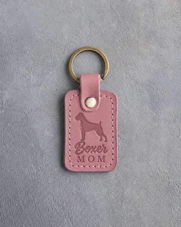 Parisian Blossom pink leather keychain debossed with a Boxer silhouette and the words Boxer MOM, on gray concrete