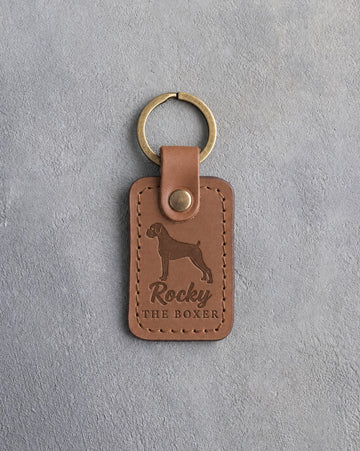 Caramel leather keychain debossed with a Boxer silhouette, the name Rocky and THE BOXER, on gray concrete