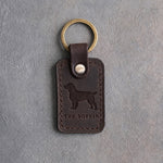 Dark espresso leather keychain debossed with a Boykin spaniel above THE BOYKIN, on gray concrete
