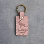 Blush pink leather keychain debossed with a Brittany silhouette and the words Brittany MOM, on gray concrete