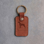 Arizona tan leather keychain debossed with a Brittany silhouette above THE BRITTANY, on gray concrete