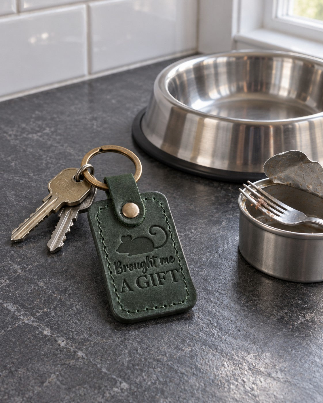 Green Brought Me a Gift keychain on a doormat by a front door in early morning light