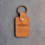 Indian Summer leather keychain debossed with a brown trout above Tight lines and BROWN TROUT, on gray concrete