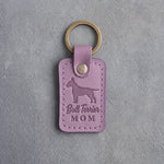 Lilac leather keychain with a debossed Bull Terrier and the words Bull Terrier MOM, on gray concrete