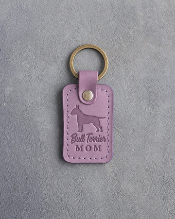 Lilac leather keychain with a debossed Bull Terrier and the words Bull Terrier MOM, on gray concrete