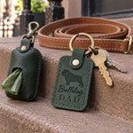 Green Bulldog Dad keychain on the couch cushion beside a TV remote on a lazy afternoon