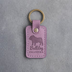 Lilac leather keychain debossed with an English bulldog silhouette and the words Bulldog GRANDMA, on gray concrete