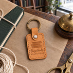 Tan Buys books READS SOME keychain clipped to a canvas tote full of new books outside a bookshop
