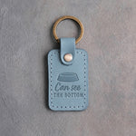Turquoise leather keychain debossed with an empty cat food bowl above the words Can see THE BOTTOM