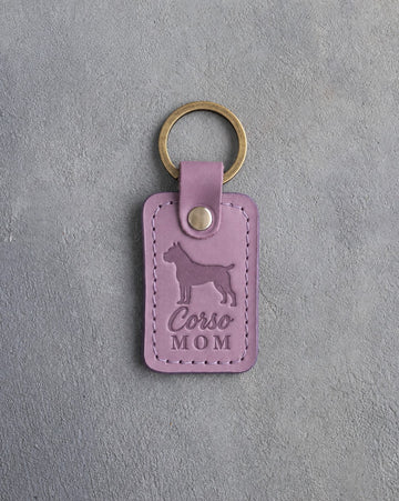 Lilac leather keychain with a debossed Cane Corso and the words Corso MOM on gray concrete