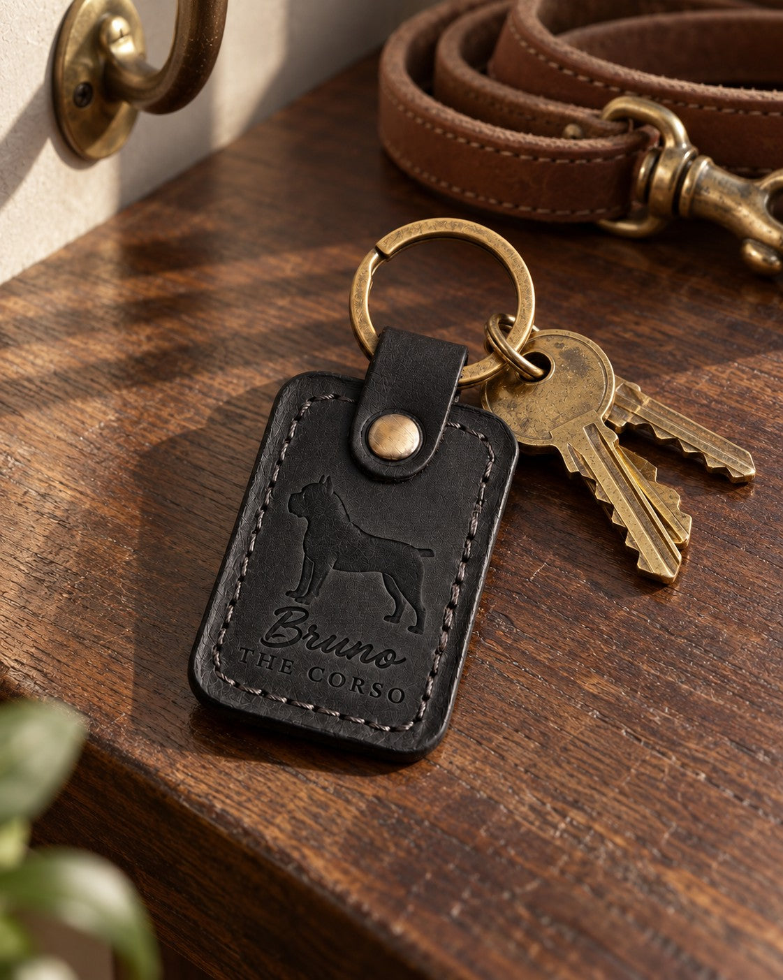Bruno the Corso keychain in black leather with car keys on a dark wood console