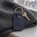 Navy On the Sill memorial keychain resting on a windowsill at dusk