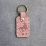 Blush pink leather keychain debossed with a cat sitting on a windowsill above the words Cat MOM